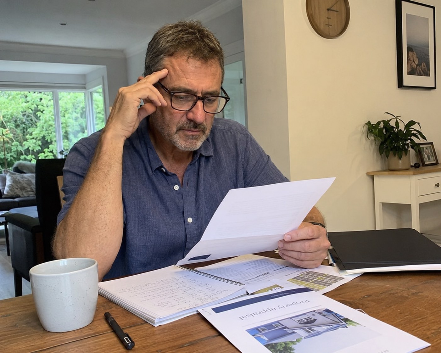 A Gold Coast homeowner reviewing a real estate agency agreement at their kitchen table.